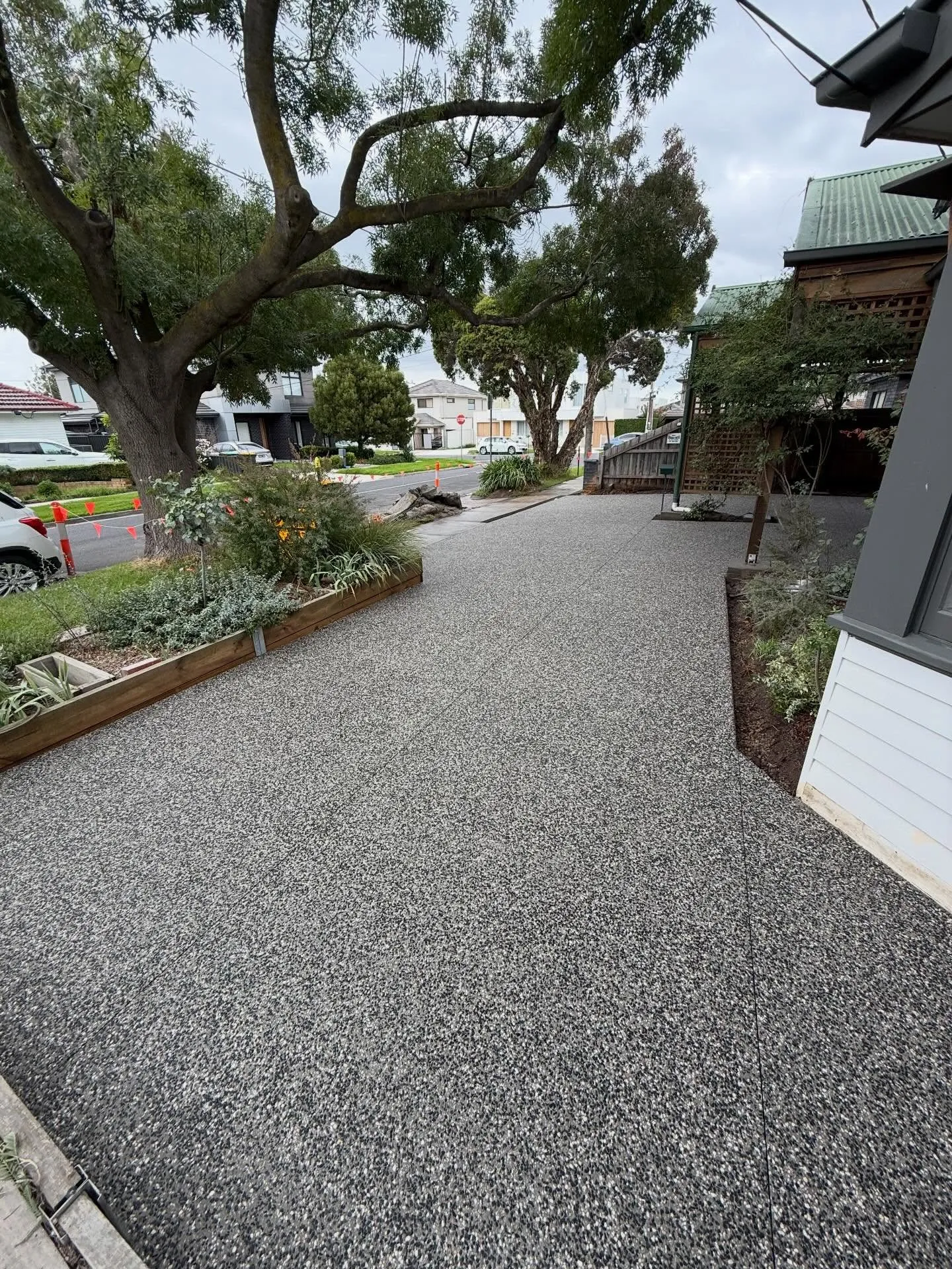 Wide exposed aggregate driveway under a huge gum tree at a period weatherboard home