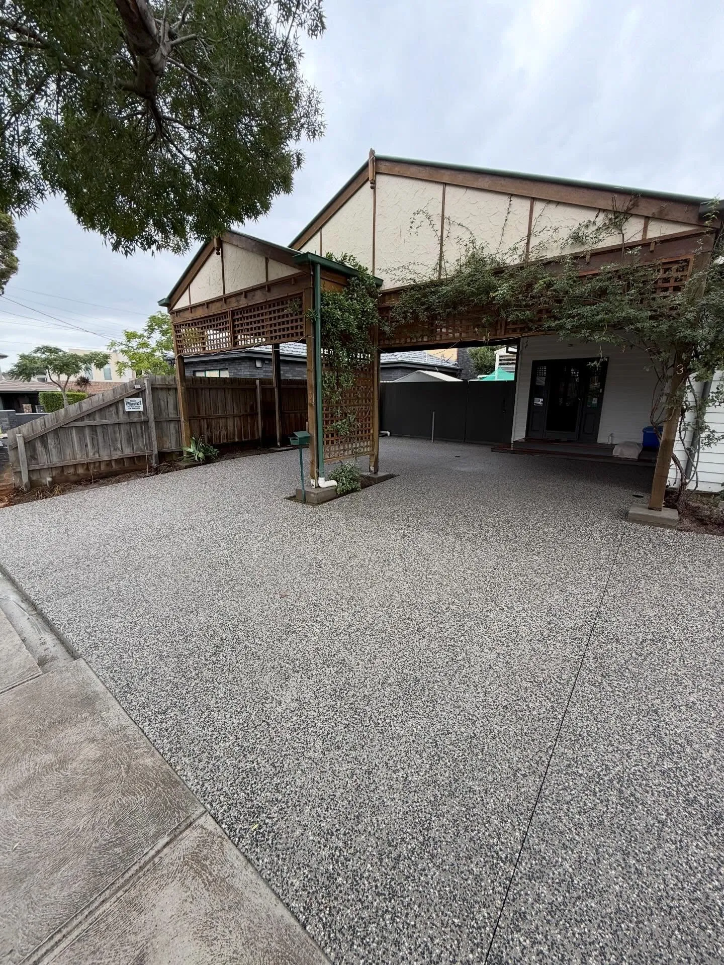 Exposed aggregate driveway leading up to the ornate weatherboard porch
