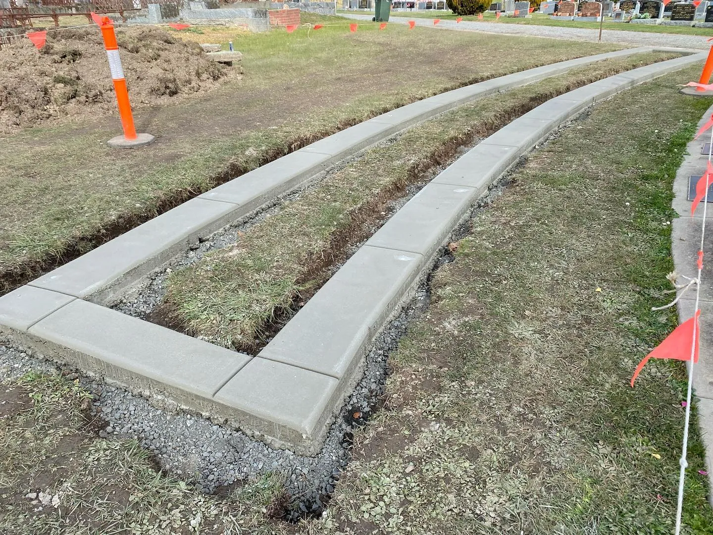 Twin curved concrete kerb-edged paths through a memorial garden