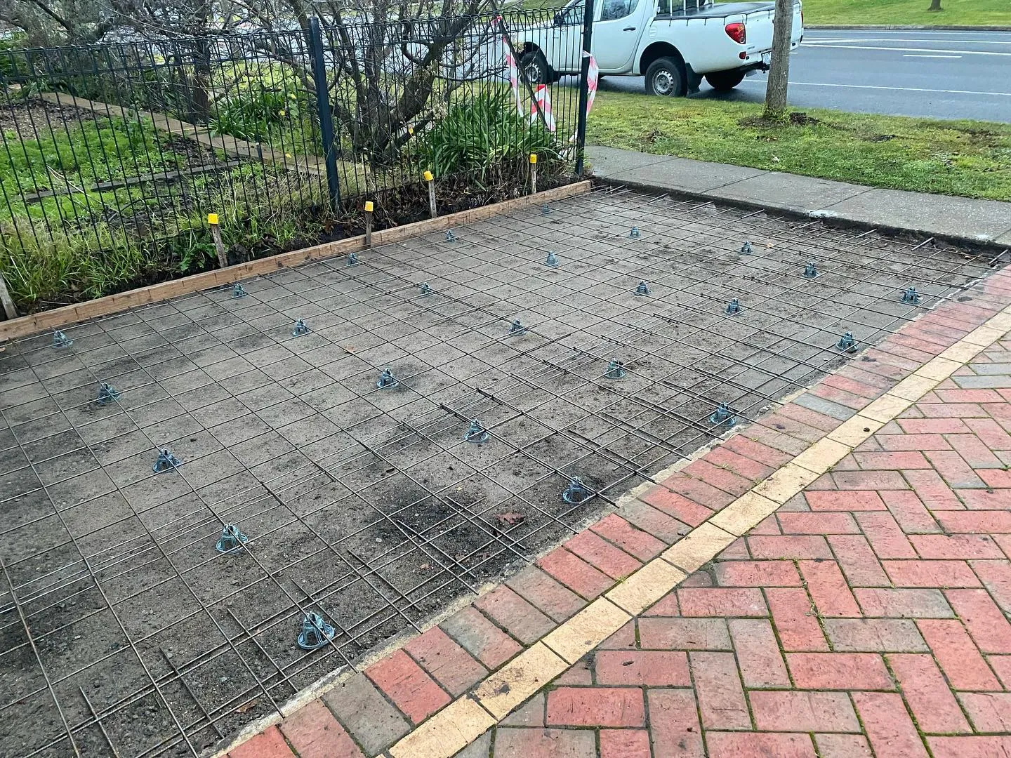 Mesh and chairs laid over crushed rock for the side entry pad with a ute on the road behind