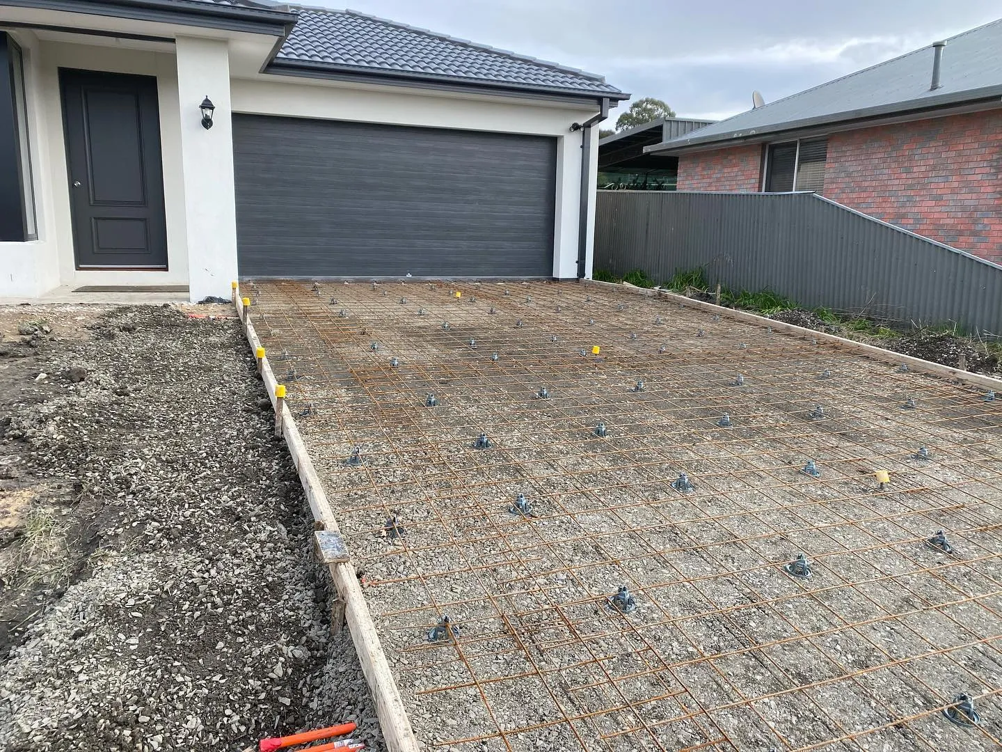 Mesh, chairs and formwork laid in front of a double garage ready for the charcoal pour