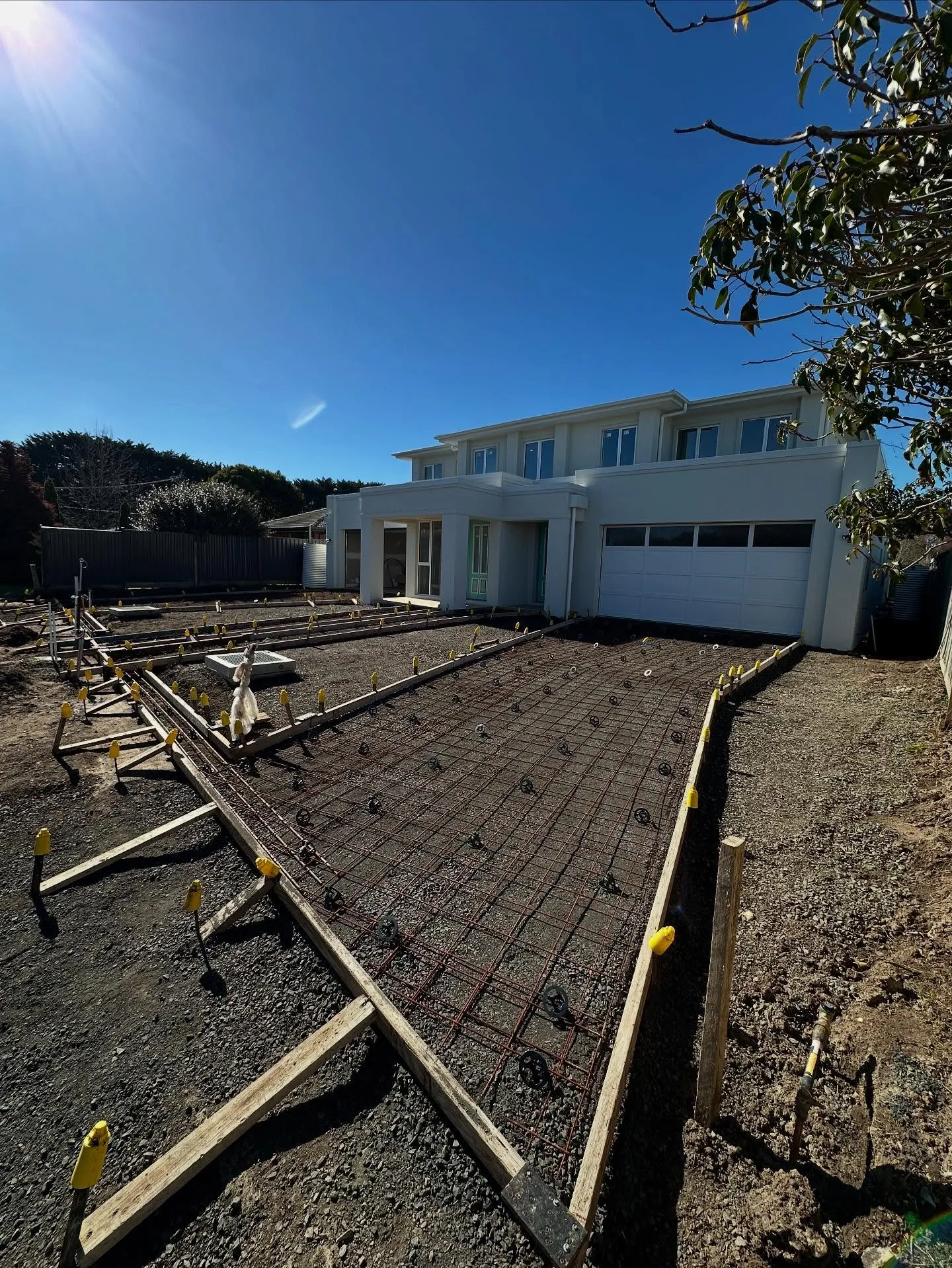 Mesh formwork laid for the twin driveways in front of the white two-storey home