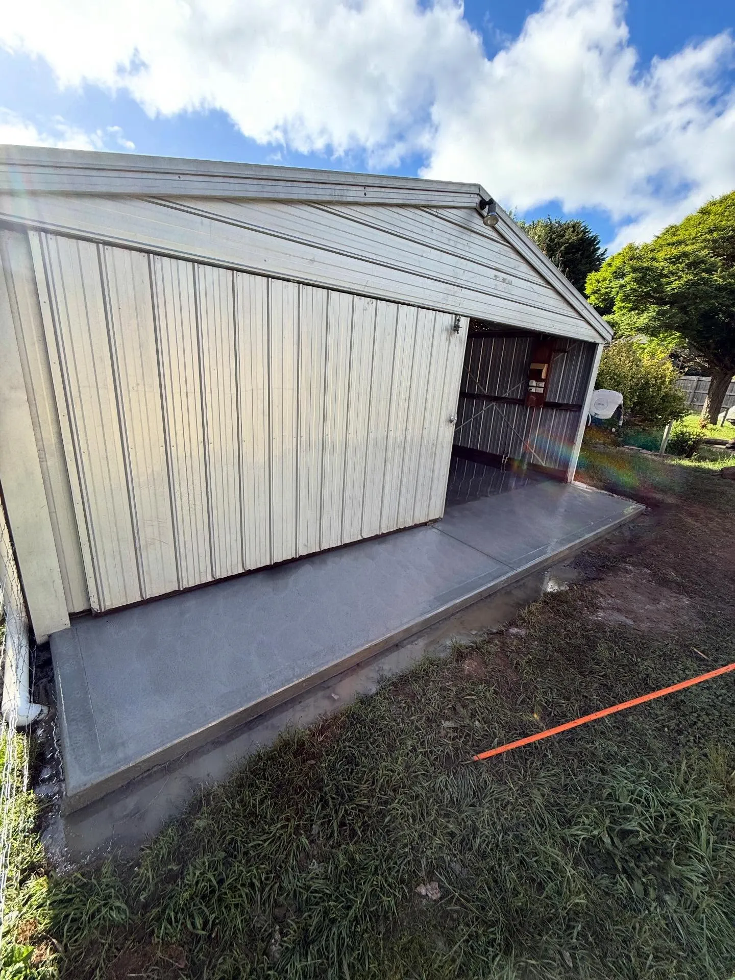 Finished concrete floor under the steel roller-door of a small garage